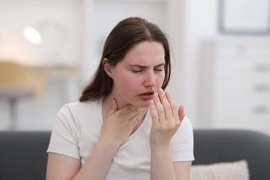 Photo of Young woman suffering from sore throat at home