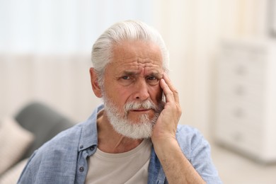 Photo of Senior man suffering from toothache at home
