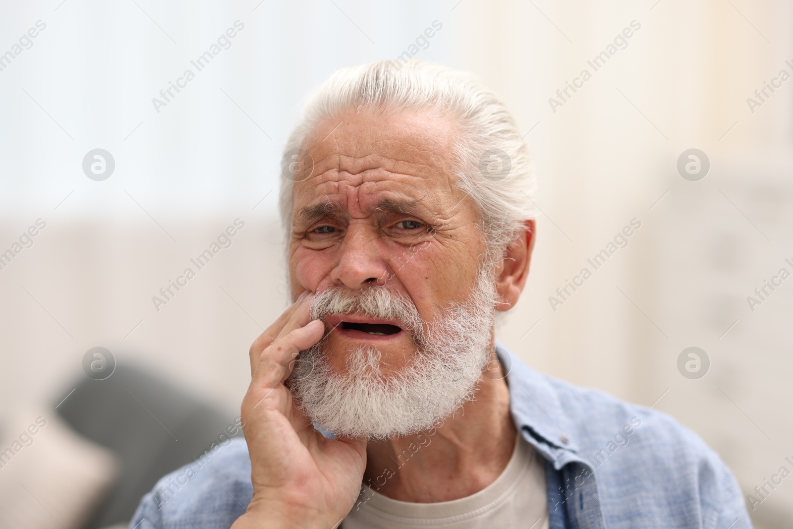 Photo of Senior man suffering from toothache at home