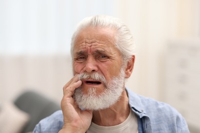 Photo of Senior man suffering from toothache at home
