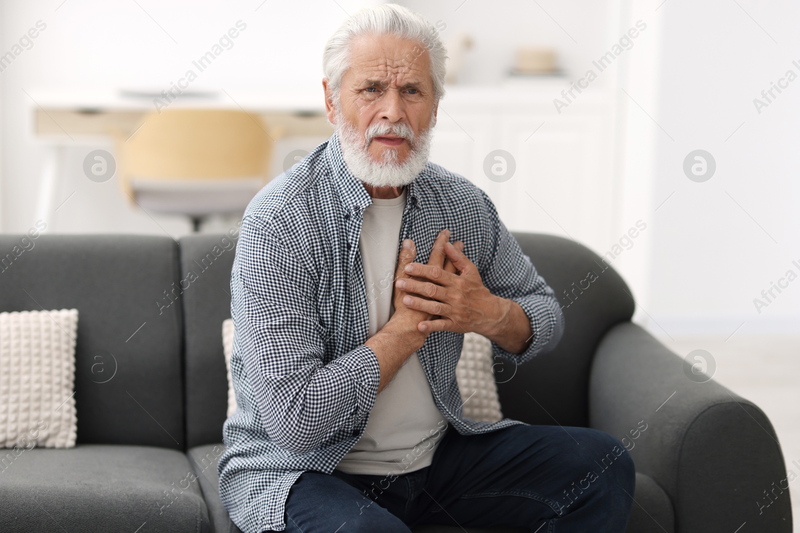 Senior man suffering from chest pain at home Photo of Senior man suffering from chest pain at home