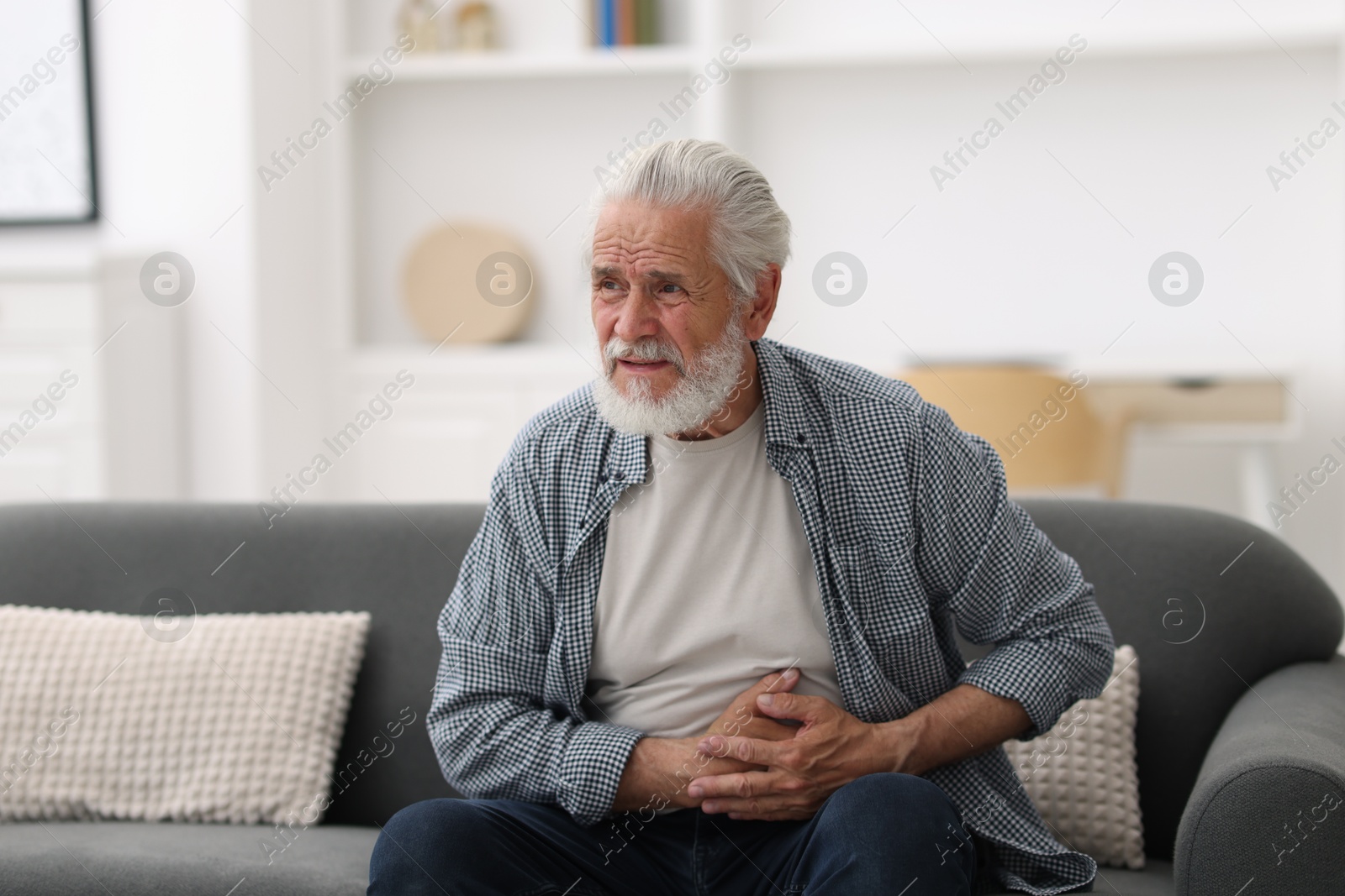 Photo of Senior man suffering from stomachache at home