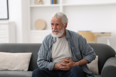 Photo of Senior man suffering from stomachache at home