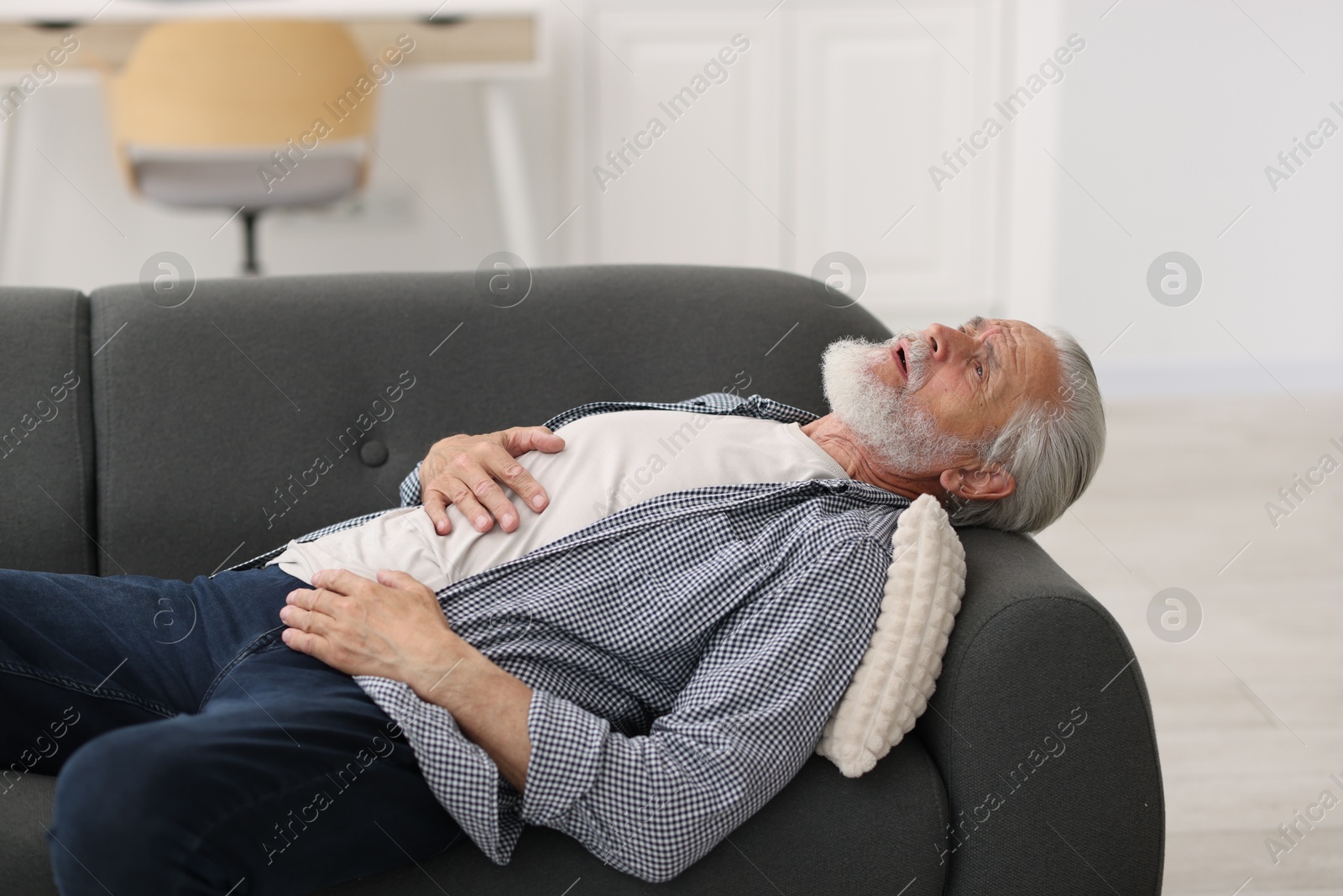 Photo of Senior man suffering from stomachache at home