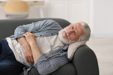 Photo of Senior man suffering from stomachache at home