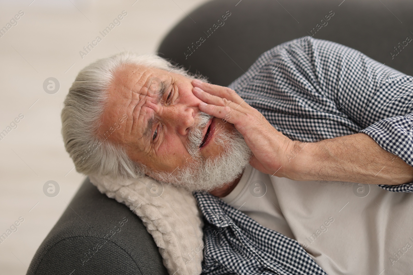 Senior man suffering from toothache at home Photo of Senior man suffering from toothache at home