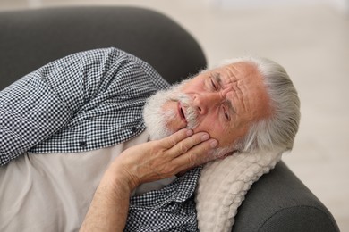 Photo of Senior man suffering from toothache at home