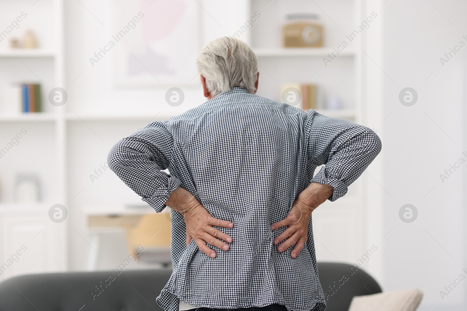 Photo of Senior man suffering from back pain at home