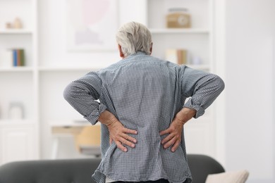 Photo of Senior man suffering from back pain at home
