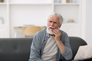 Photo of Senior man suffering from toothache at home