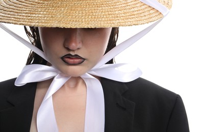 Photo of Beautiful young woman with black lip liner wearing straw hat on white background, closeup