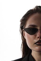 Photo of Beautiful young woman with black lip liner wearing wet sunglasses on white background, closeup