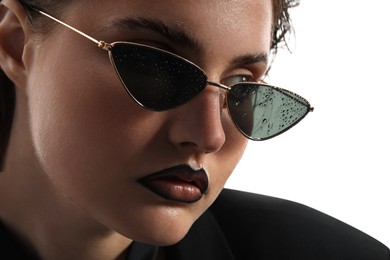 Photo of Beautiful young woman with black lip liner wearing wet sunglasses on white background, closeup