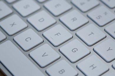 Photo of Modern white wireless keyboard as background, closeup