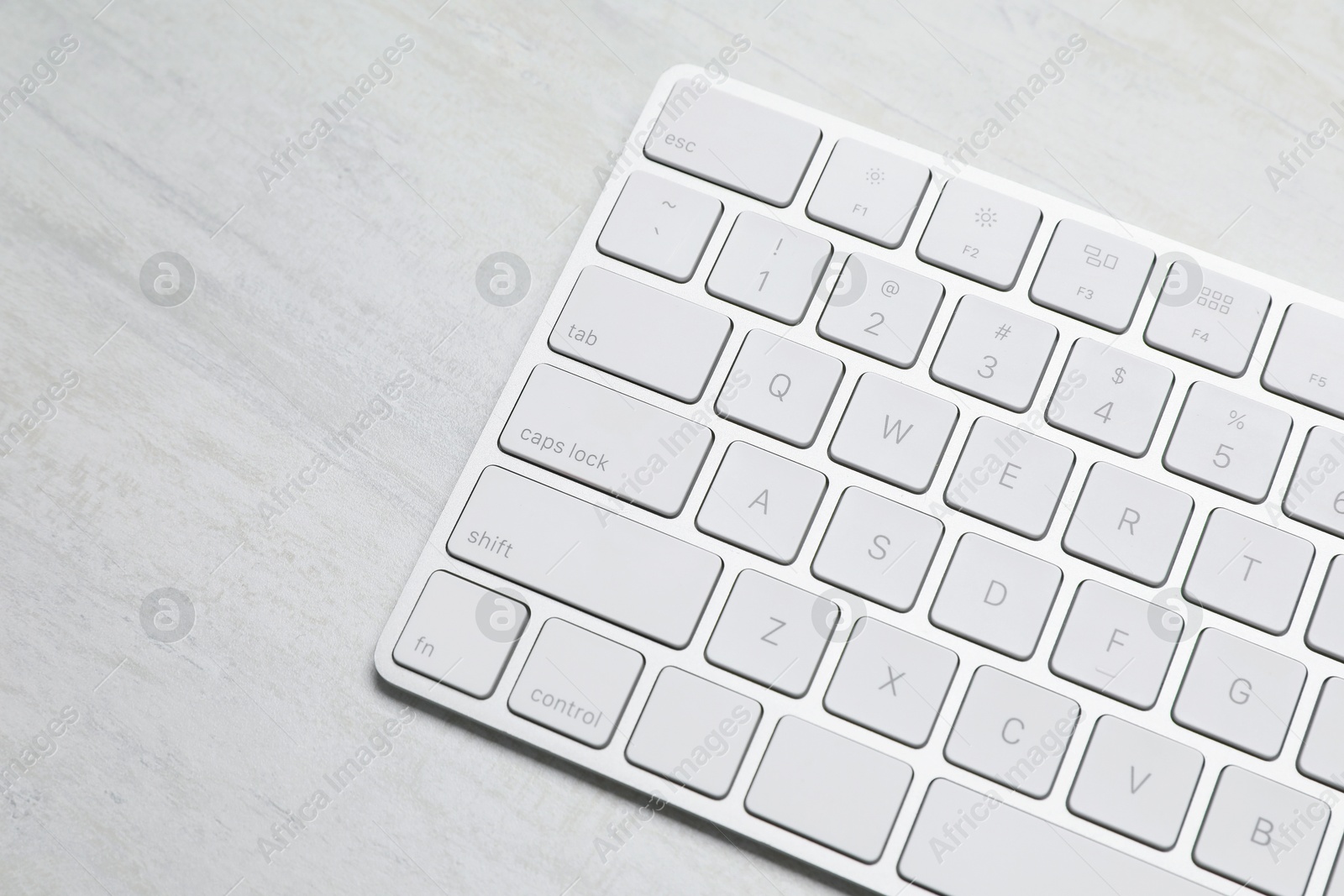 Modern wireless keyboard on white wooden table, above view. Space for text Photo of Modern wireless keyboard on white wooden table, above view. Space for text