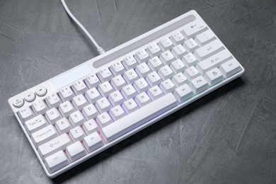 Photo of Modern white keyboard with RGB lighting on grey table