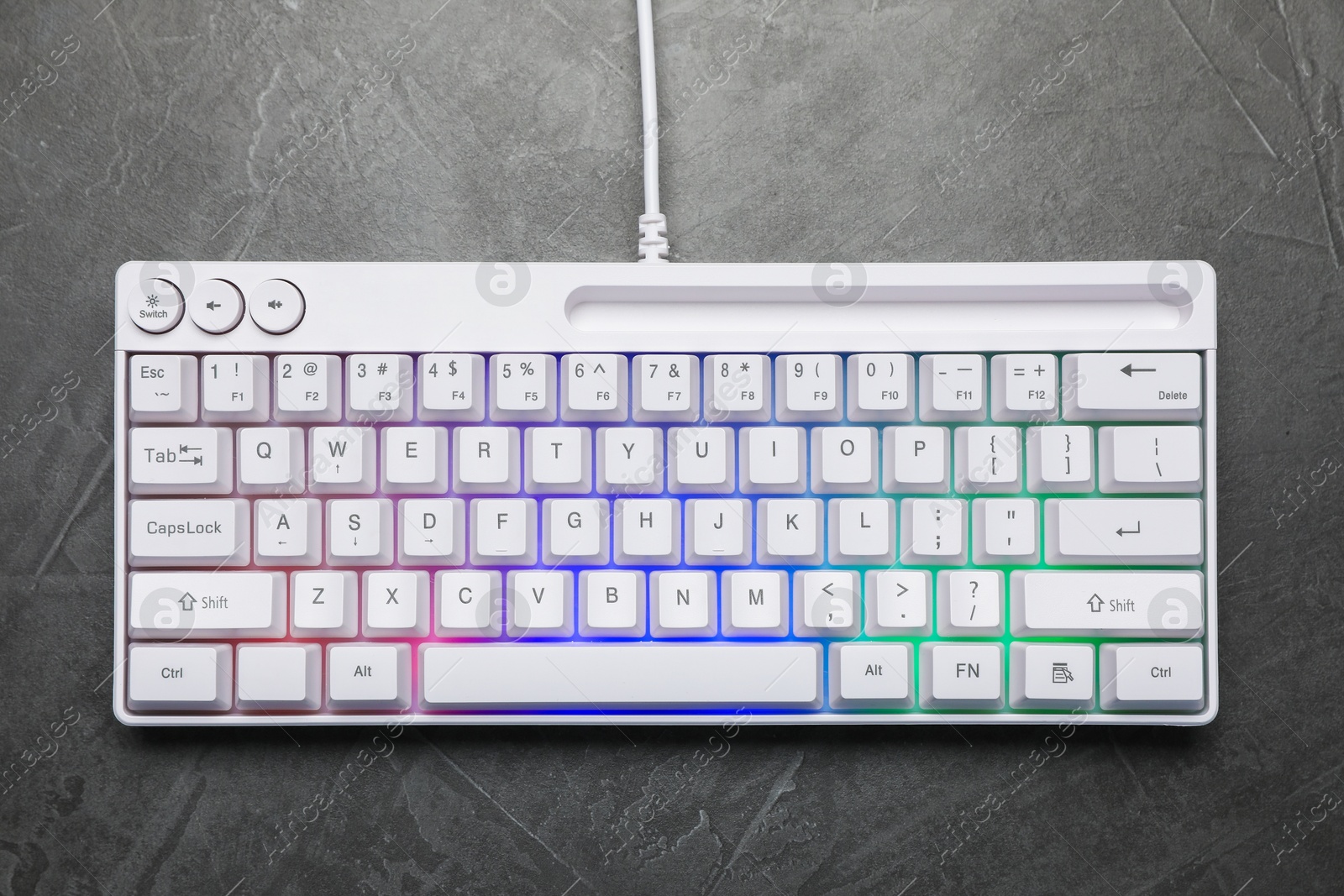 Modern white keyboard with RGB lighting on grey table, top view Photo of Modern white keyboard with RGB lighting on grey table, top view