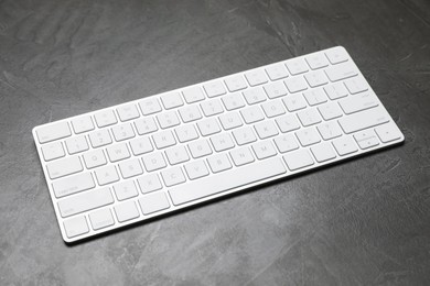 Photo of Modern white wireless keyboard on grey table