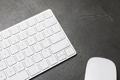 Photo of Modern white wireless keyboard and mouse on grey table, above view