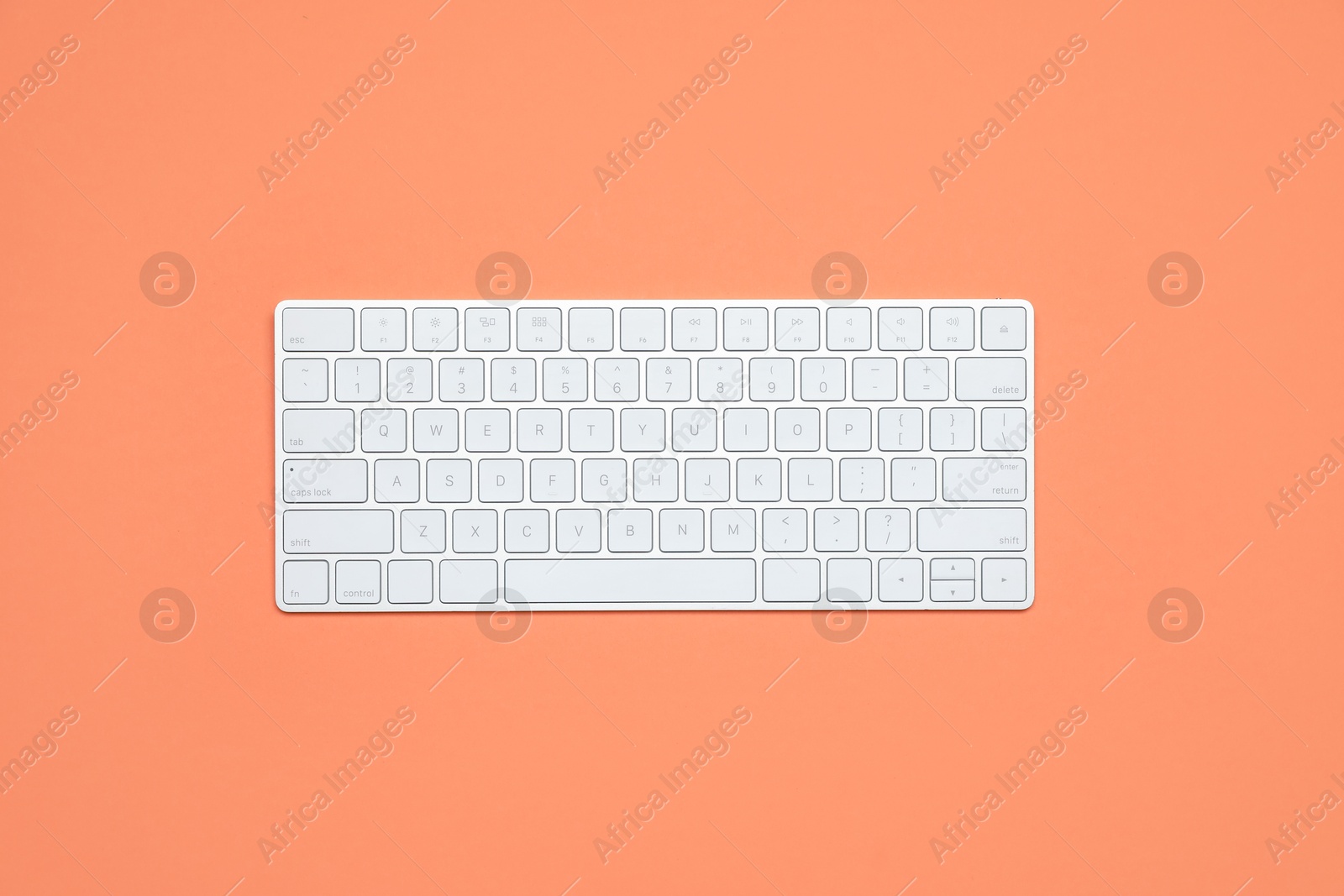 Modern white wireless keyboard on color background, top view Photo of Modern white wireless keyboard on color background, top view