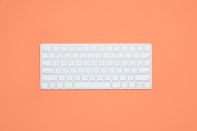 Photo of Modern white wireless keyboard on color background, top view