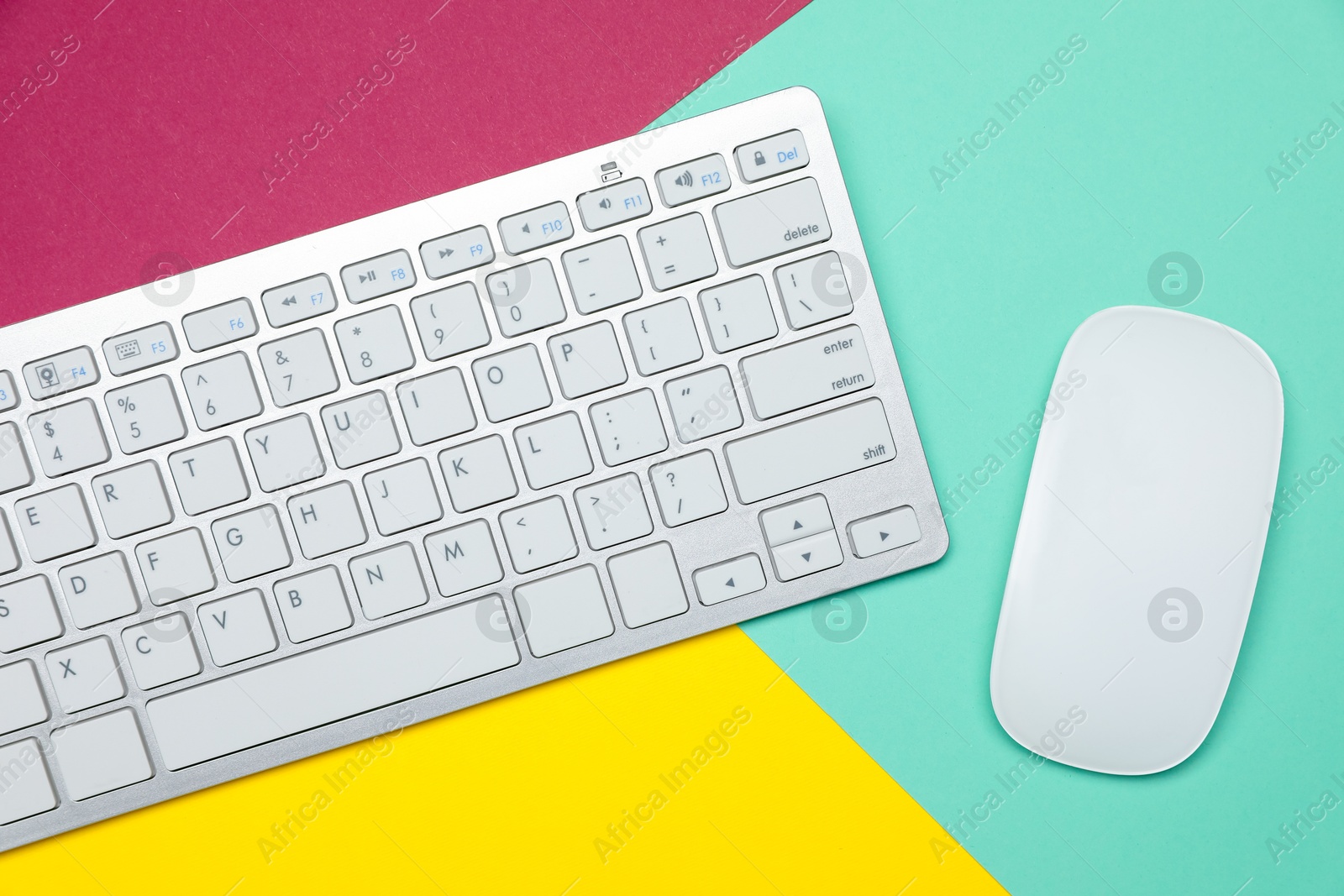 Modern white wireless keyboard and mouse on color background, top view Photo of Modern white wireless keyboard and mouse on color background, top view