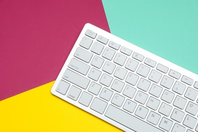 Photo of Modern white wireless keyboard on color background, top view. Space for text