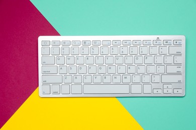 Photo of Modern white wireless keyboard on color background, top view