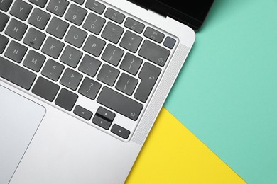 Photo of Modern laptop with keyboard on color background, top view. Space for text