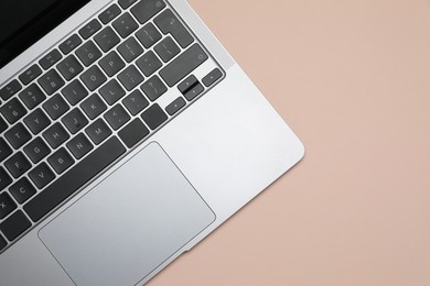 Photo of Modern laptop with keyboard on beige background, top view. Space for text
