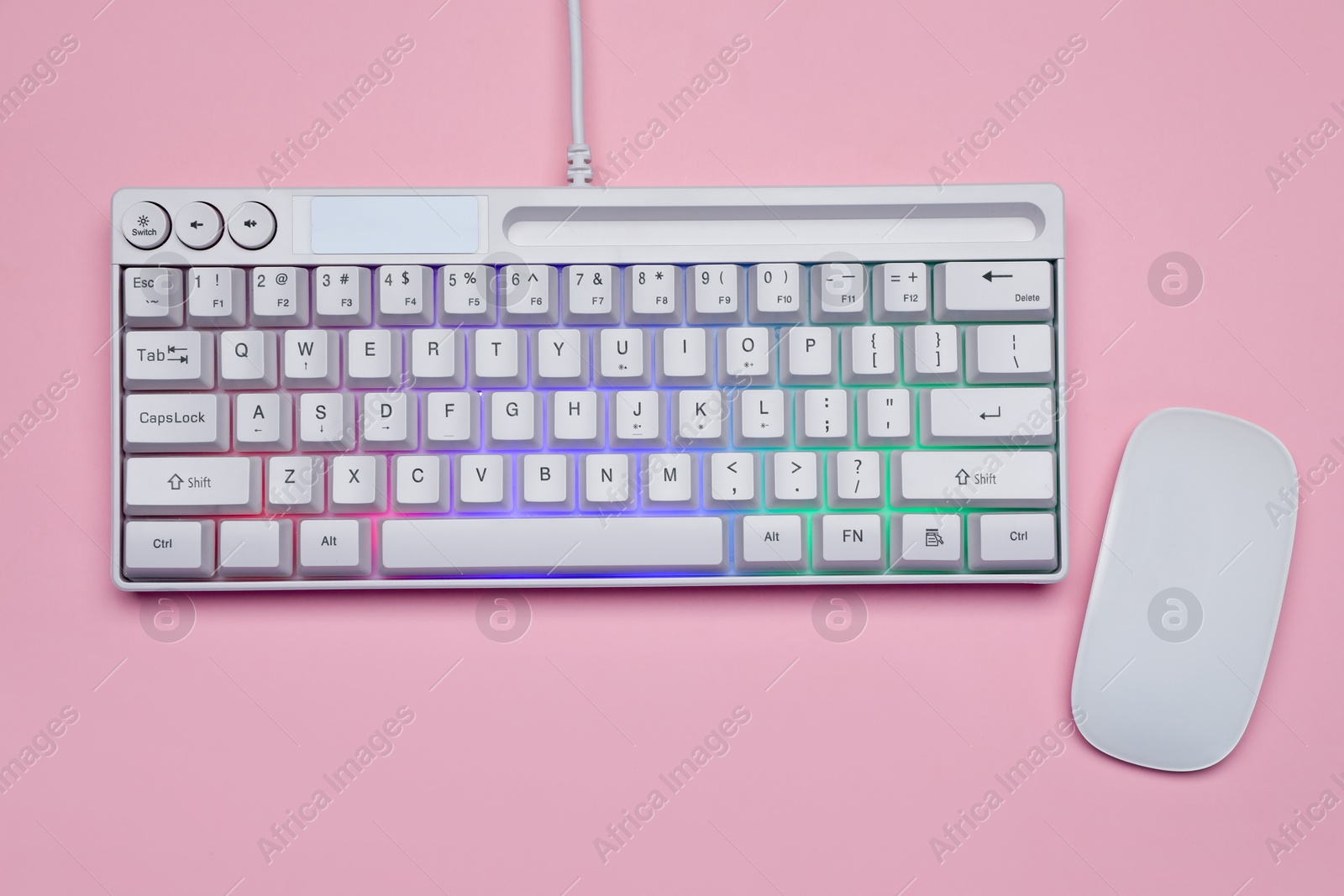 White keyboard with RGB lighting and mouse on pink background, top view Photo of White keyboard with RGB lighting and mouse on pink background, top view
