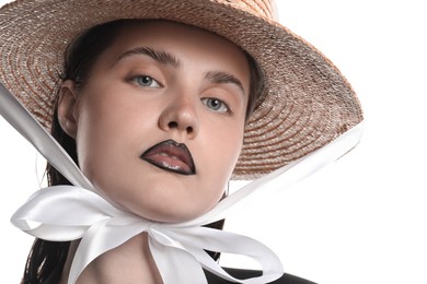 Photo of Beautiful young woman with black lip liner wearing straw hat on white background, closeup