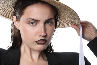 Photo of Beautiful young woman with black lip liner wearing straw hat on white background