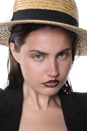 Photo of Beautiful young woman with black lip liner wearing straw hat on white background, closeup