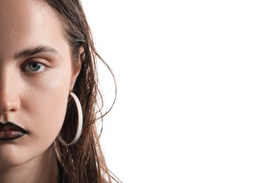 Photo of Beautiful young woman with black lip liner wearing stylish earrings on white background, closeup