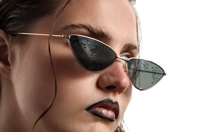 Photo of Beautiful young woman with black lip liner wearing wet sunglasses on white background, closeup