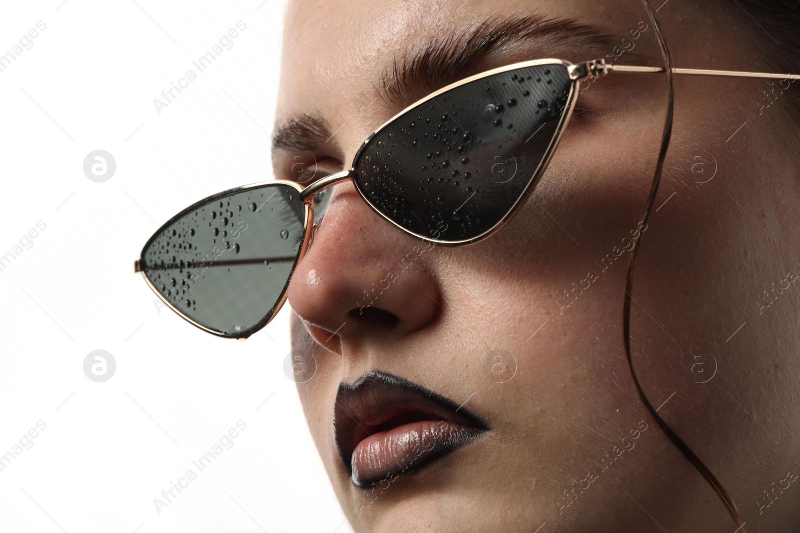 Beautiful young woman with black lip liner wearing wet sunglasses on white background, closeup Photo of Beautiful young woman with black lip liner wearing wet sunglasses on white background, closeup
