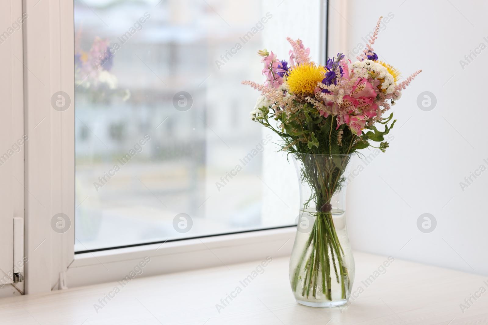 Bouquet of beautiful flowers on windowsill indoors, space for text Photo of Bouquet of beautiful flowers on windowsill indoors, space for text