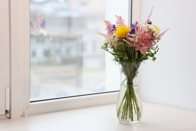 Photo of Bouquet of beautiful flowers on windowsill indoors, space for text