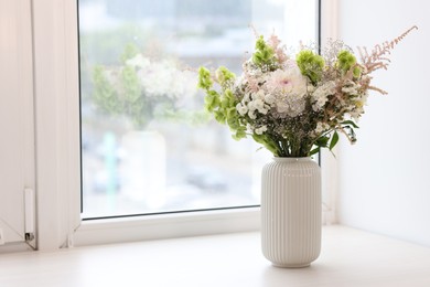 Photo of Bouquet of beautiful flowers on windowsill indoors, space for text