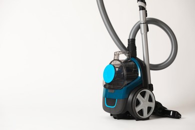 Photo of One vacuum cleaner on light grey background. Space for text