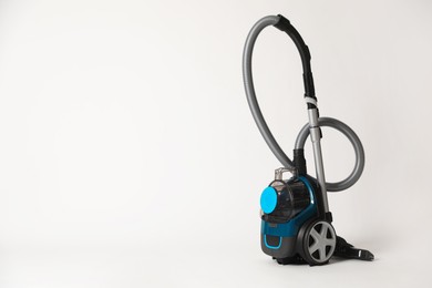 Photo of One vacuum cleaner on light grey background. Space for text