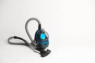 Photo of One vacuum cleaner on light grey background. Space for text