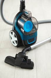 Photo of One vacuum cleaner on wooden floor. Household appliance