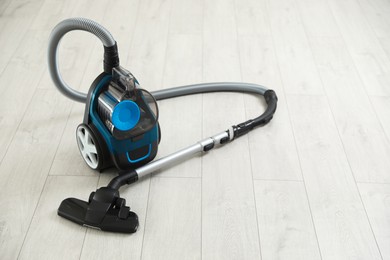 Photo of One vacuum cleaner on wooden floor. Household appliance