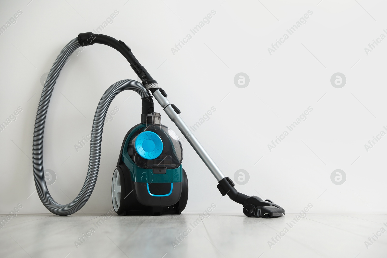 One vacuum cleaner on floor near white wall Photo of One vacuum cleaner on floor near white wall