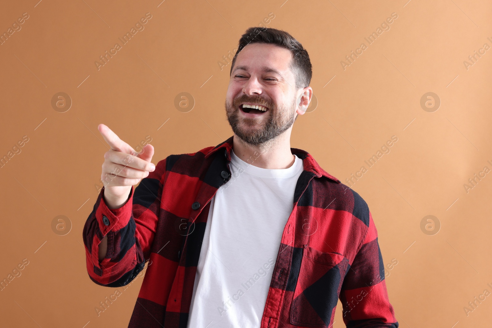 Photo of Handsome man laughing on dark beige background