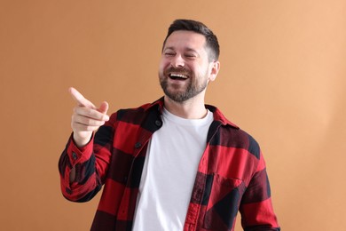 Photo of Handsome man laughing on dark beige background