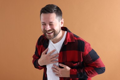 Photo of Handsome man laughing on dark beige background