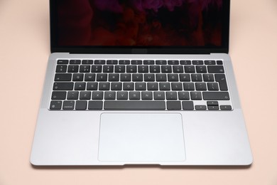 Photo of Modern laptop with keyboard on beige background, closeup